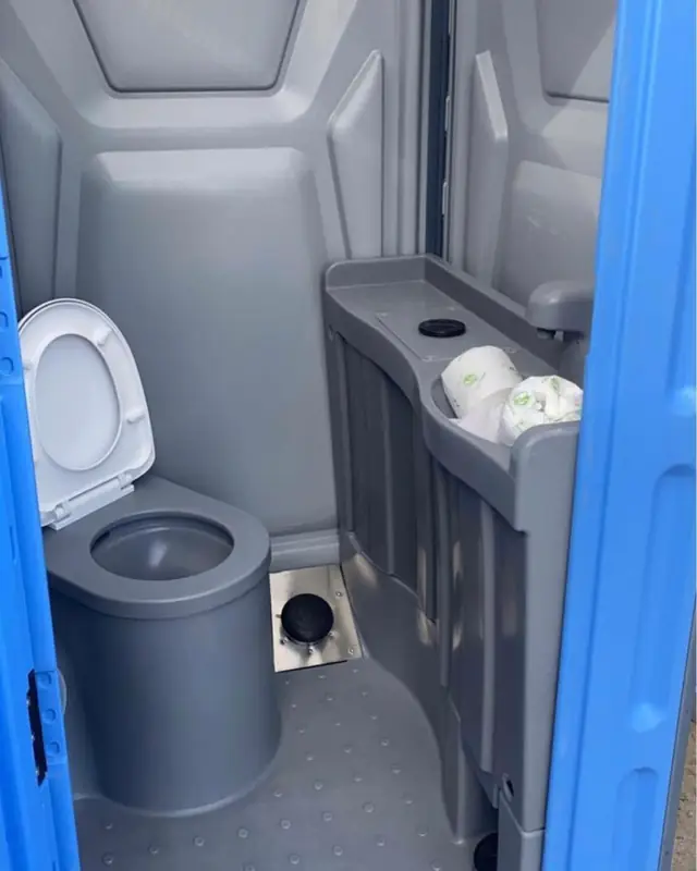 Interior of a deluxe porta potty with sink and seat