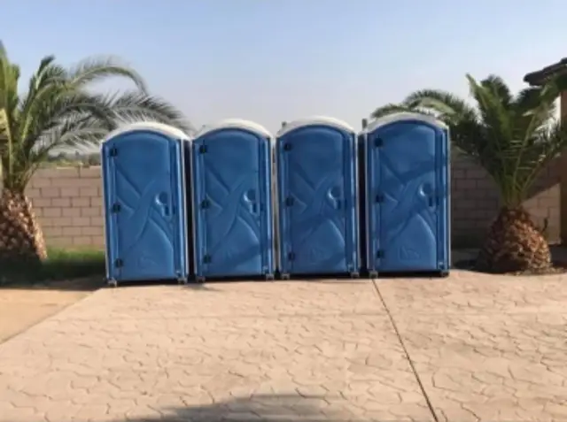 Row of blue event porta potties on a paved lot