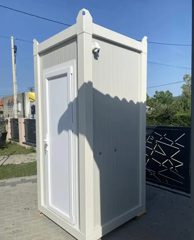 White flushing restroom cabin on a driveway, the kind of unit we deliver in Belleville